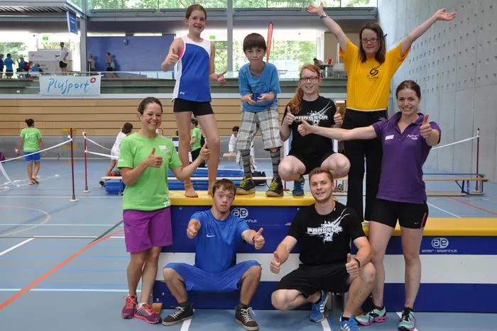 Jugendliche Gruppe posiert nach dem Sport fröhlich in der Sporthalle